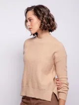 Sweater de punto tramado color rosa, de cuello alto y manga larga.