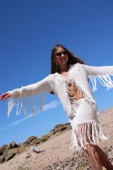 Pollera corta tejida a mano en crochet color blanco, con detalle de flecos en el ruedo.