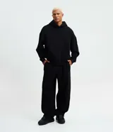 Pantalón baggy de corte ancho y relajado, color negro, con cintura elástica con cordón ajustable, bolsillos laterales y bajos con elástico regulable.