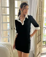 Vestido corto negro con cuello camisero blanco, mangas 3/4 con puños blancos y corte ajustado.