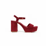 Sandalia de fiesta Dalia color bordó, confeccionada en gamuza de cuero legítimo. Cuenta con diseño de tira frontal ancha, taco ancho, plataforma y pulsera ajustable al tobillo con hebilla metálica.