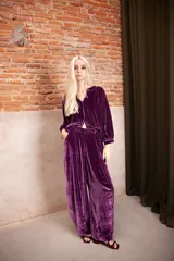 Pantalón de tiro medio confeccionado en terciopelo color violeta, con corte amplio y caída fluida.