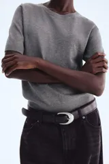 Remera de manga corta en punto fino de mezcla de viscosa, color gris jaspeado. Presenta escote redondo, puños y bajo en punto acanalado.