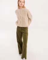 Pantalón de pana color verde oliva, de corte wide leg y largo al tobillo. Tiene cierre delantero con botón, bolsillos laterales y traseros.