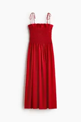 Vestido midi rojo en mezcla de viscosa, con cuerpo fruncido tipo nido de abeja, escote recto, tirantes finos ajustables con moñas y falda amplia con vuelo.