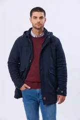 Saco de paño azul marino con capucha desmontable, cierre frontal oculto, bolsillos laterales con tapa y detalles en los puños.