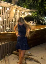 Pollera corta dorada de tejido de punto con lurex y volado en el ruedo.