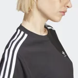 Remera negra de corte clásico con cuello redondo y mangas cortas. Presenta tres rayas blancas en contraste en los hombros y el logo de Adidas bordado en el pecho.