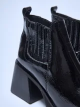 Botín negro de charol con elásticos laterales, punta cuadrada y taco bloque.