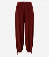 Pantalón estilo aladino color bordó, confeccionado en tejido crepé con textura. Presenta cintura elástica, corte holgado en las piernas y ruedo ajustado con lazo decorativo.
