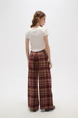Pantalon de corte recto y tiro alto, con estampado de cuadros en tonos marrones y bordó. Presenta bolsillos laterales y cierre frontal.