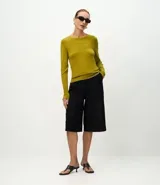 Suéter de punto ajustado con cuello redondo y manga larga. Presenta detalle de botones metalizados en los puños.