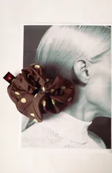 Colitapelo scrunchie de tela marrón con lunares amarillos.
