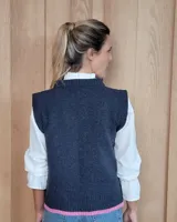 Chaleco tejido de punto con diseño abstracto en bloques de color marrón y turquesa, con cuello redondo y terminaciones acanaladas.