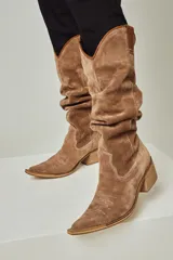 Botas texanas de caña alta, confeccionadas en cuero negro, con taco cuadrado de 5 cm y punta fina.