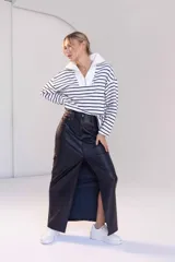 Falda midi gris de cuero sintético, corte recto y abertura frontal.