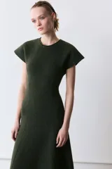 Vestido largo de punto en color verde oscuro jaspeado, con cuello redondo, manga corta y falda con corte evasé.