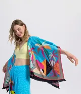 Kimono abierto de manga corta amplia, confeccionado en viscosa con estampado tropical de tucanes y palmeras sobre fondo celeste, con detalles en rosa, amarillo y negro, y terminación de flecos en los bordes.