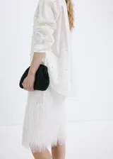 Camisa oversize blanca de mezcla de algodón y lyocell, con cuello camisero, manga larga, puños abotonados y detalle de perlas aplicadas en toda la prenda.