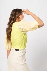 Blusa verde con cuello redondo y mangas cortas abullonadas.