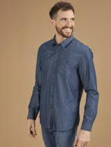 Camisa de manga larga azul con pequeños lunares blancos, cuello clásico y bolsillo en el pecho.