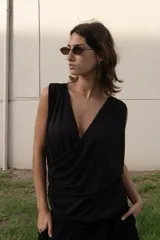 Blusa negra sin mangas de microtul con escote en V drapeado y corte holgado. 