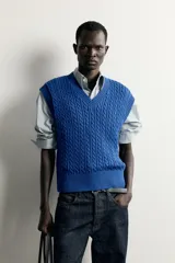 Chaleco de punto trenzado color azul, de corte relaxed fit, con cuello en V y sisas acabadas en rib.