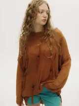 Sweater de punto semiabierto color naranja, con diseño holgado tipo vestido, detalles rasgados, flecos y canutillos de madera. Presenta bordados en crochet en cuello y puños, con pespuntes en hilo grueso en la sisa.