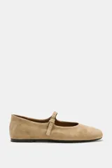 Zapato tipo bailarina de ante color beige, con punta redonda, suela plana de 1 cm y tira delantera con hebilla metálica.