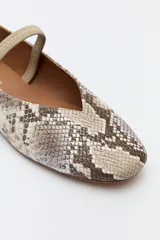 Balerina negra de cuero sintético con punta redondeada, escote en V y tira elástica sobre el empeine.