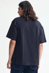 Remera de punto de algodón de peso medio en color negro, con cuello redondo ribeteado, hombros caídos, mangas cortas y corte relajado.
