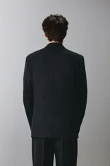 Blazer cruzado regular fit negro, con solapa de pico, bolsillos con solapa en la cadera, bolsillo de vivo en el pecho y cierre frontal con doble botonadura.