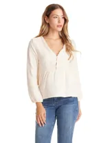 Blusa de algodón color beige con escote en V, cierre frontal con botones y detalles de puntilla en el frente. Presenta mangas largas amplias con puños elastizados y un diseño con bordados sutiles.