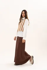 Chaleco tejido a rayas beige y blanco, con escote en V y cierre con ganchitos.