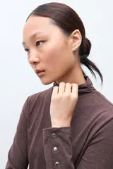 Media polera de manga larga con cuello alto y detalle de frunces en los puños, confeccionada en tejido suave y elástico.