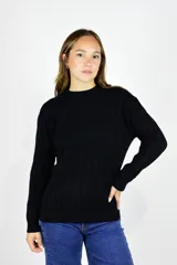 Buzo de punto color negro con diseño de trenzas o espigas, cuello redondo, mangas largas y puños y ruedo elásticos con ribete.