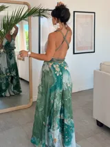 Vestido largo verde con diseño estampado tipo tie-dye y detalles dorados, de corte fluido, un solo hombro y diseño amplio.