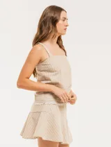 Musculosa de lino a rayas verticales azules y blancas, con breteles anchos y ruedo con flecos.