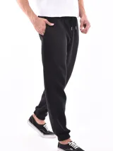 Pantalón jogger negro de felpa, con cintura elástica ajustable mediante cordón y puños elásticos en los tobillos.