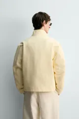 Cazadora regular fit de algodón color amarillo claro, con cuello alto, cierre frontal de cremallera y bolsillos de vivo en la cadera.