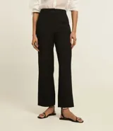 Pantalón de vestir gris oscuro, de corte recto, con bolsillos laterales y traseros. Se ajusta a la cintura con cinturón de cuero marrón.