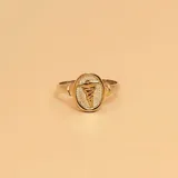 Anillo de plata 925 con apliques en oro 18k, con un dije ovalado con el símbolo de la medicina.