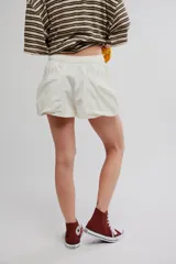 Short corto color blanco de mezcla de lino y algodón, con calce relajado, cintura con cordón ajustable y grandes bolsillos delanteros envolventes.