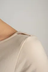 Remera color crema de algodón y elastano, de corte ajustado y mangas largas, con cuello barco.