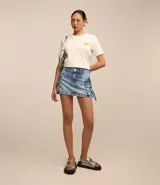 Pollera mini de jean con efecto mármol, diseño de tiro medio con bolsillos cargo laterales, lazos decorativos con hebillas y cierre frontal tradicional.