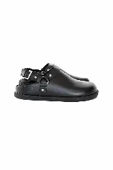 Zueco destalonado tipo slingback de napa negra, con tira ajustable en el talón, hebilla metálica y argolla lateral decorativa con tachas.