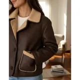 Campera tipo gamulán de ecocuero marrón con forro y detalles de corderito en cuello, solapas y bolsillos. Presenta cierre frontal con botones y dos bolsillos externos.