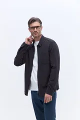 Camisa de manga larga con textura, color gris oscuro, con cuello clásico, cierre frontal de botones y un bolsillo en el pecho.