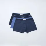 Pack de tres bóxers para hombre en tonos azules. Incluye un modelo azul marino con estampado geométrico de rombos pequeños, un modelo liso en tono azul medio y un modelo a rayas horizontales finas en tonos azul marino y celeste. Todos cuentan con cintura elástica con una pequeña etiqueta central.