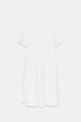 Vestido camisero de lino con cuello solapa, manga corta y cierre frontal con botones. Presenta un diseño con bajo redondeado y aberturas laterales.